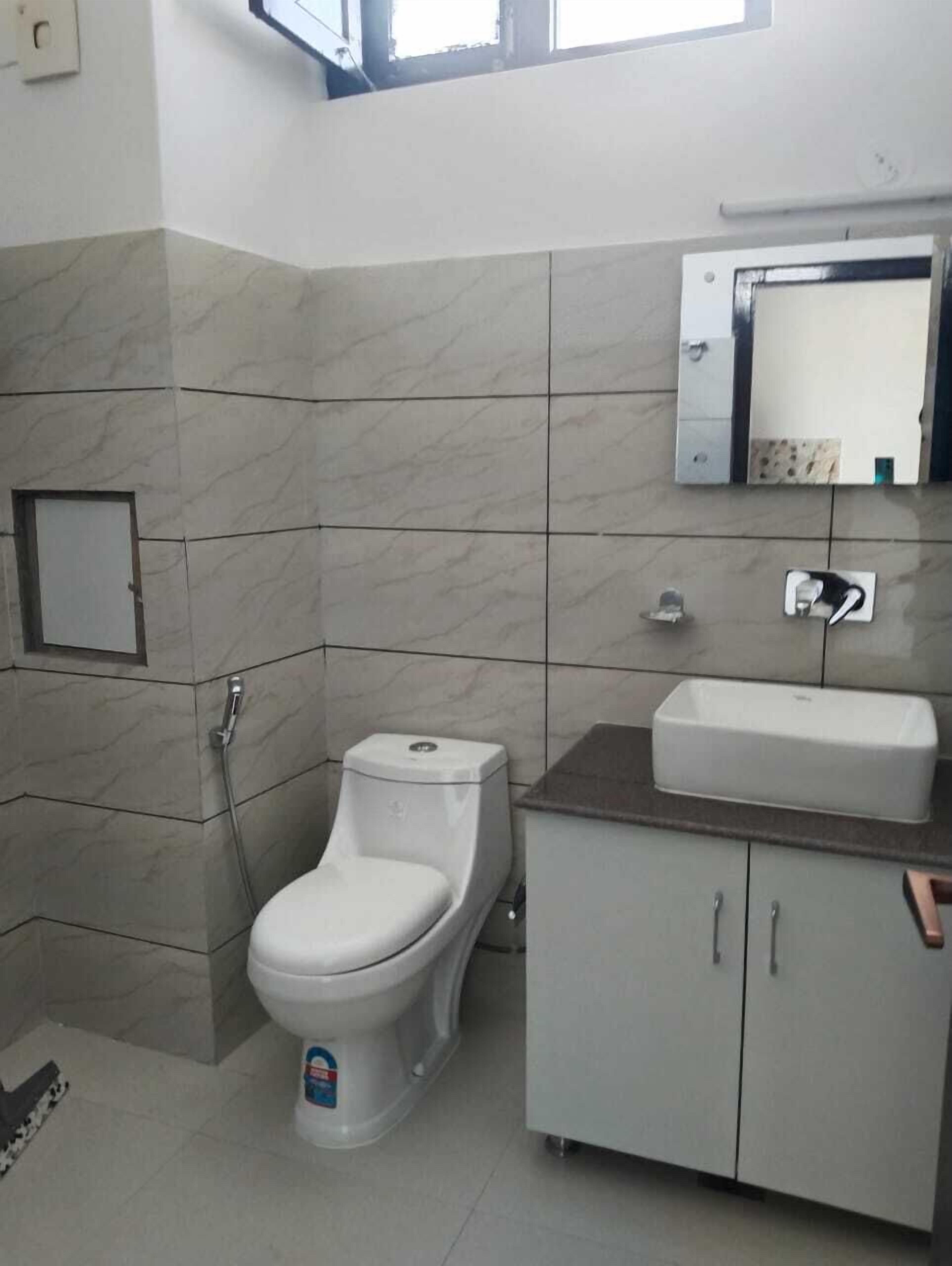 Un baño con inodoro, lavabo y armario.