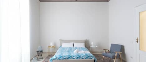 Une chambre à coucher comprenant un lit, une chaise, une table de chevet et un plafond décoratif.