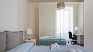 A hotel room with a bed, a desk, a chair, and a mirror. - Darsena Apartments by Wonderful Italy (Syracuse)