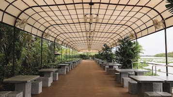 Walk along the tranquil path lined with stone benches under a curved metal roof.