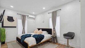 Un dormitorio moderno con una cama, una silla y una planta en maceta.