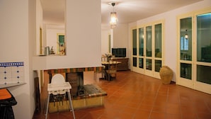Amplia sala de estar con chimenea, una mesa de comedor y un ventanal con vistas.