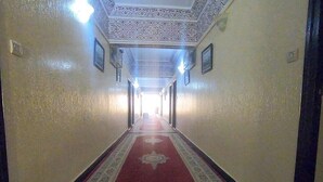 Un couloir avec un tapis à motifs, des murs à motifs et un plafond à motifs.