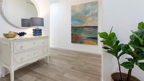 A room with a white dresser, a round mirror, a lamp, and a painting on the wall. - Genteel Home San Pablo Terrace (Córdoba)