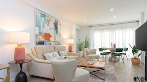 A modern living room with a sofa, armchairs, a coffee table, and a dining area with chairs and a table. - Genteel Home San Pablo Terrace (Córdoba)
