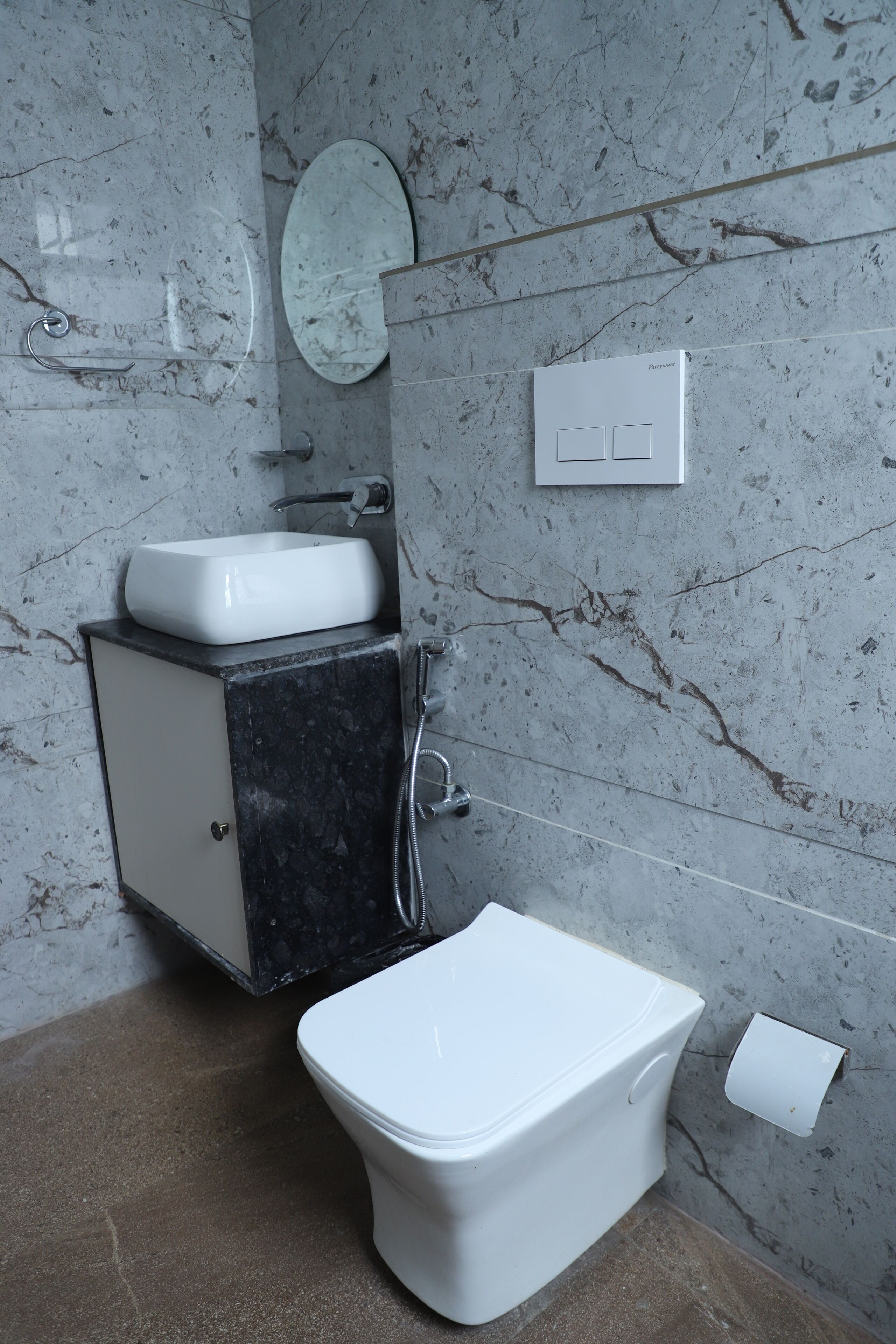 Un baño con inodoro blanco, lavabo y espejo en la pared.