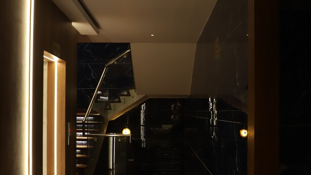 A modern interior with a marble floor, a staircase, and a wall with a geometric pattern. - Hotel Shree Darshnam (Mathura)