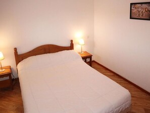 Cozy retreat with a single bed, bedside tables, and a framed picture.