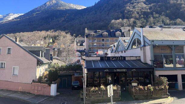 A building with a sign reading "Le Braseo" in a town setting with mountains in the background. - Charming 2-bedroom apartment in Cauterets (Cauterets)
