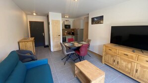Una sala de estar moderna con un sofá, un televisor y un mueble de madera.