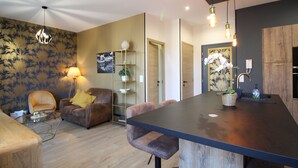 Ein modernes Wohnzimmer mit einer Couch, einem Couchtisch und einem Essbereich mit einer Bar.