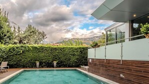 A modern outdoor swimming pool with a wooden deck and a view of the sky and mountains. - Hotiday Torbole Lago (Nago-Torbole)