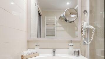A bathroom with a white sink, a mirror, and a hairdryer.