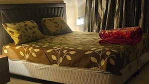 A bedroom with a bed, a nightstand, a wall-mounted lamp, and a window with curtains. - Furnished Studio Appartment in Burdubai  (Dubai)