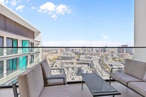 Un balcon avec vue sur la ville, deux canapés et une table.