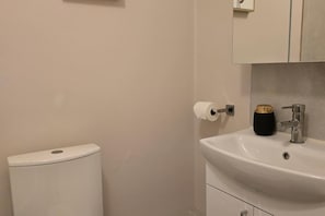 A bathroom with a toilet, a sink, and a mirror. - Dublin - 3 Bedroom Cosy Home - Sleeps Max 7 (Dublin)
