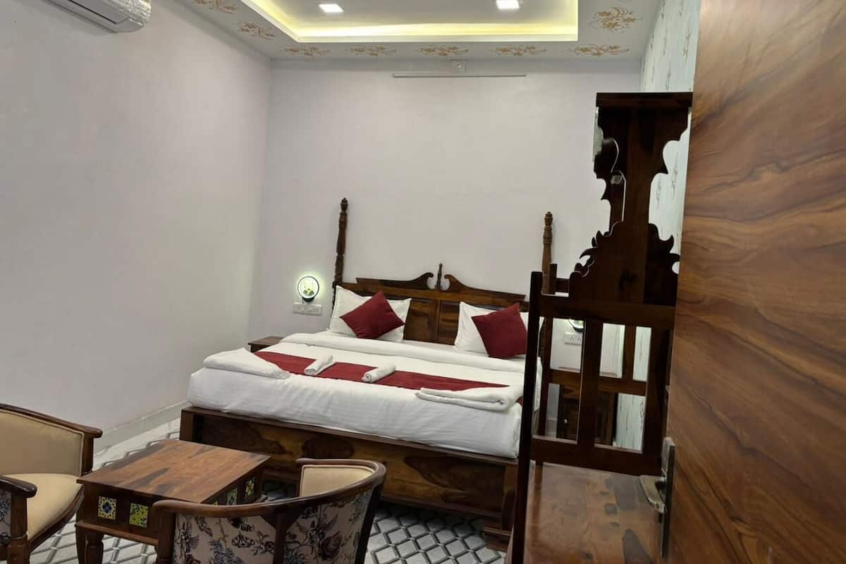 Ein Schlafzimmer mit einem hölzernen Himmelbett, einem kleinen Holztisch und einem Stuhl.