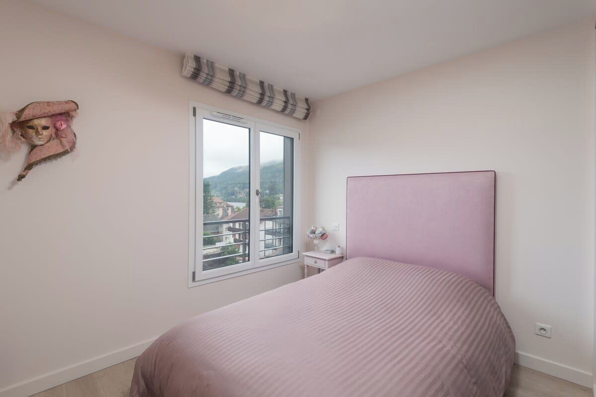 Una camera da letto con un letto singolo, una finestra vista, un comodino e un oggetto decorativo al muro.