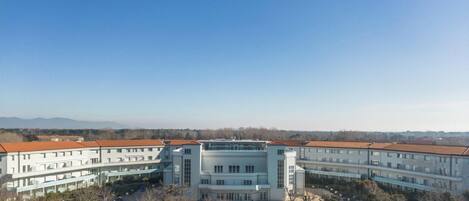 A large building with multiple floors, a central courtyard, and a swimming pool.
