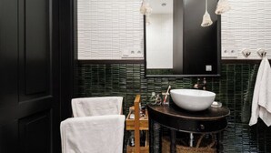 A bathroom with a white sink, a mirror, and a towel rack.