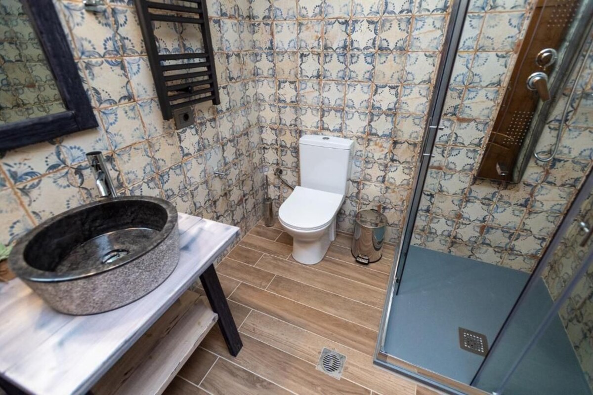 A bathroom with a toilet, a sink, and a shower.