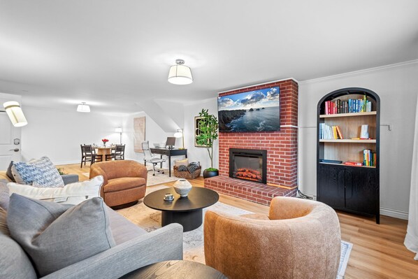 TV connectée, cheminée, livres, écrans d'ordinateur