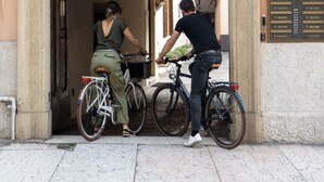 Entrada de un edificio con un letrero de ‘prohibido estacionar’, una puerta y un cartel con el número 15.