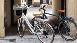Una bicicleta estacionada bajo un letrero que dice 'passo carrabile', indicando un paso de peatones.