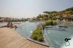 Una piscina al aire libre de temporada, sombrillas