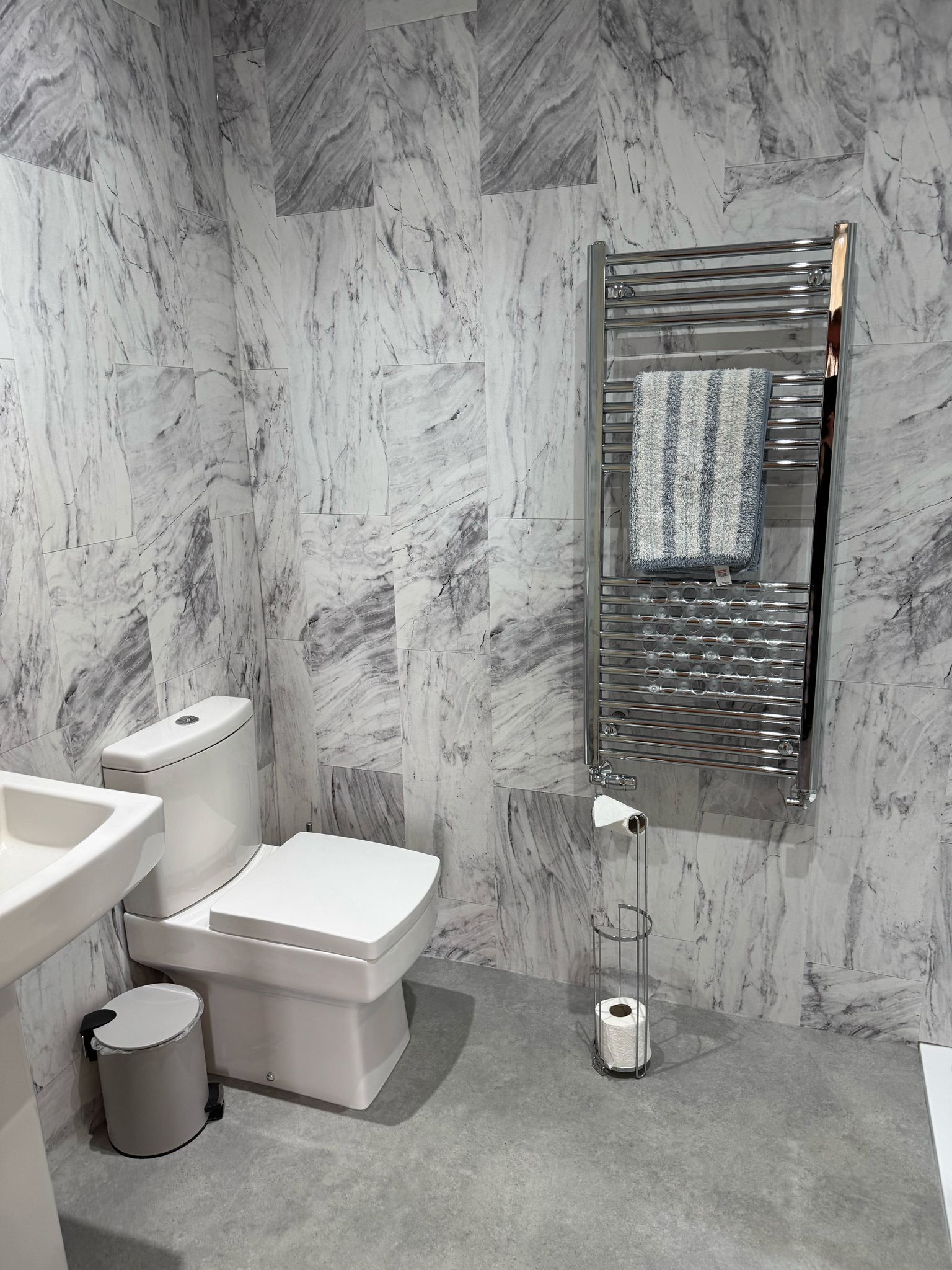 Une salle de bain moderne équipée de toilettes, d’un bidet et d’un lavabo.