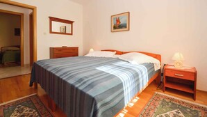 Una camera da letto con un letto, un comodino, una cassettiera e un quadro appeso al muro.