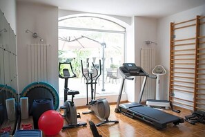A home gym with exercise equipment, a treadmill, and a large window.