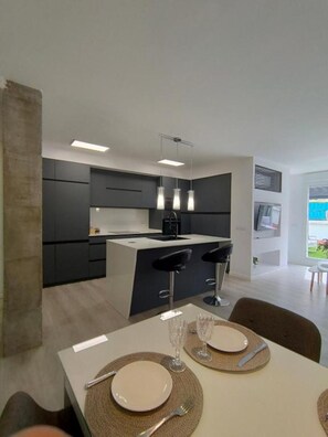 Enjoy meals in this stylish kitchen and dining area, featuring a central island and table for two.