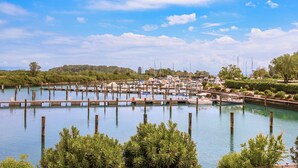 A marina with boats docked, surrounded by greenery and trees. - Hotiday Grado Marina (Grado)