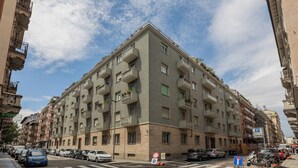 A multi-story residential building with balconies, a parking sign, and a pedestrian crossing. - Casa Gabri by Wonderful Italy (Turin)