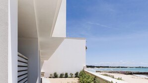 Een modern gebouw met een balkon dat uitkijkt over een strand.