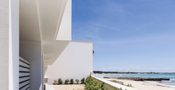 Un edificio moderno con balcón con vistas a la playa.