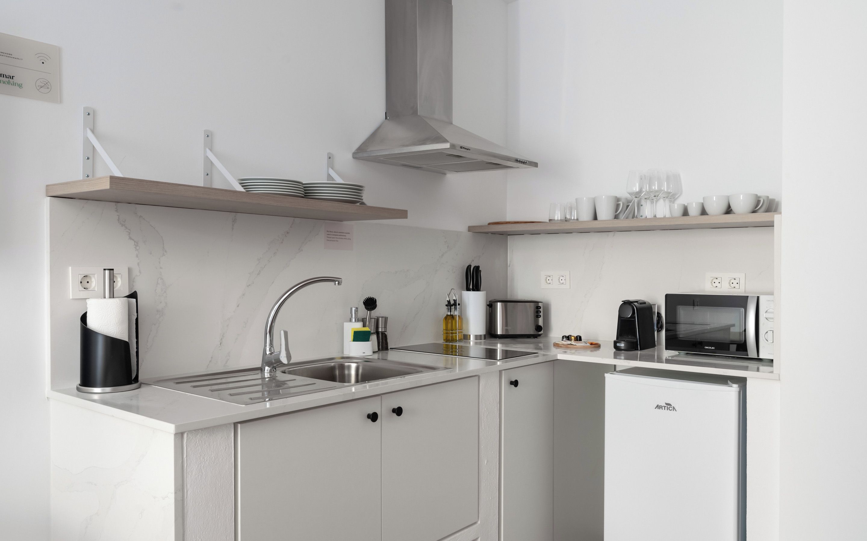 A modern kitchen with a built-in dishwasher, a microwave, and a coffee maker.