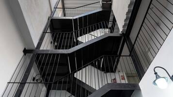 A modern building with a central staircase flanked by concrete walls and metal railings.