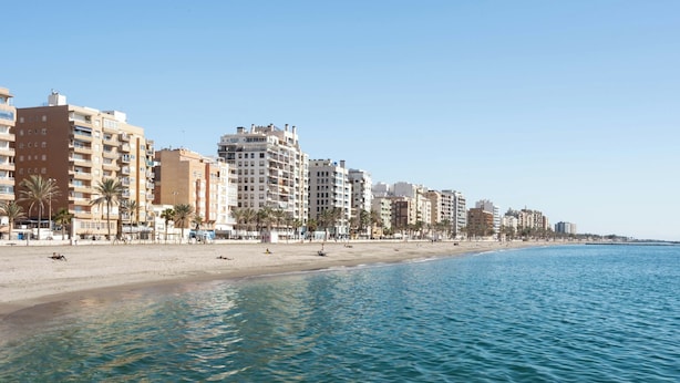 A coastal cityscape with a sandy beach and a row of multi-story buildings along the shore. - Limehome Almeria C. Hernán Cortés (Almeria)