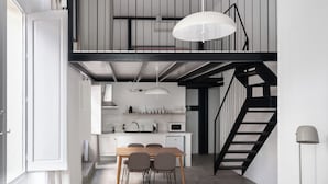 A modern kitchen with a dining area, a staircase, and a sofa. - Limehome Almeria C. Hernán Cortés (Almeria)