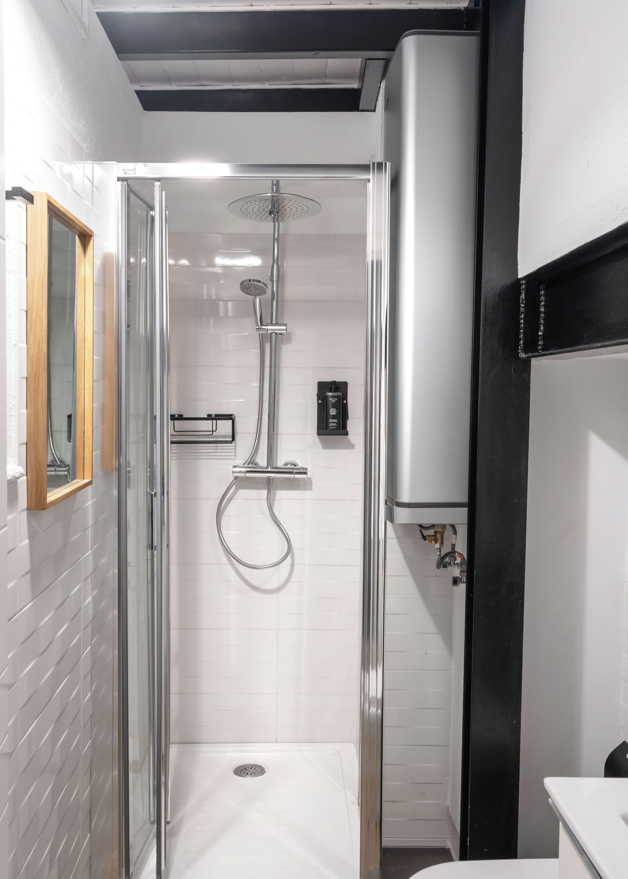 Een moderne badkamer met een glazen douchecabine, een toilet en een wastafel.
