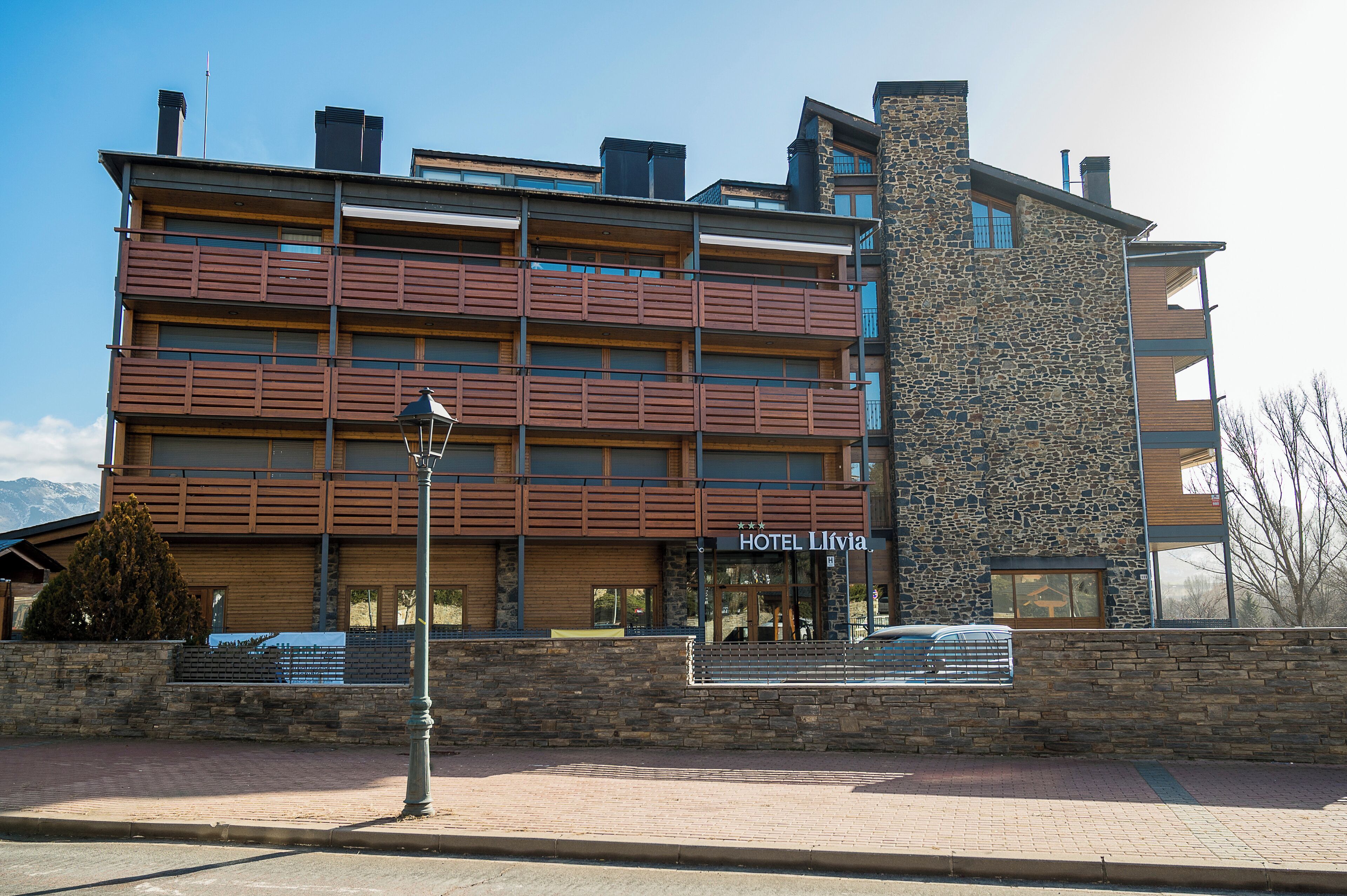 A multi-story hotel with a stone facade and wooden balconies.