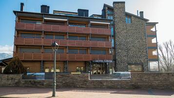 A multi-story hotel with a stone facade and wooden balconies.