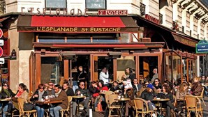 Un caffè con tavolini all'aperto, una tenda rossa e un cartello con la scritta 'L'ESPINADA St Eustache'.