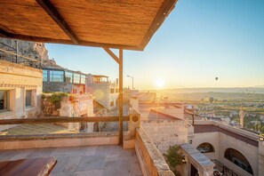 A terrace with a view of a cityscape and a sunset. - Volca Inn Cappadocia  (Nevsehir)