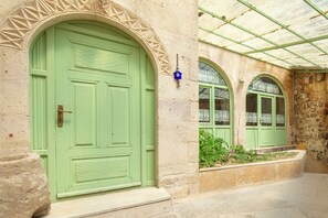 A building with a large green door, arched windows, and a stone facade. - Volca Inn Cappadocia  (Nevsehir)