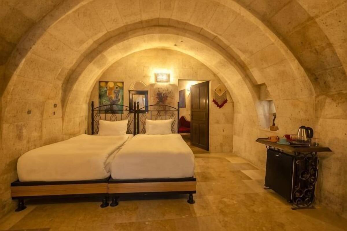 A room with a bed, a desk, and a painting on the wall.