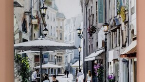 A narrow street with buildings on either side, outdoor seating, and hanging flower baskets. - Hotel A4 Wrocław (Kobierzyce)