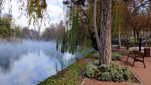 A serene riverside park with benches and trees. - Charming 2-bedroom, family friendly cottage in Miskolc at the Bükk Mountains (Miskolc)